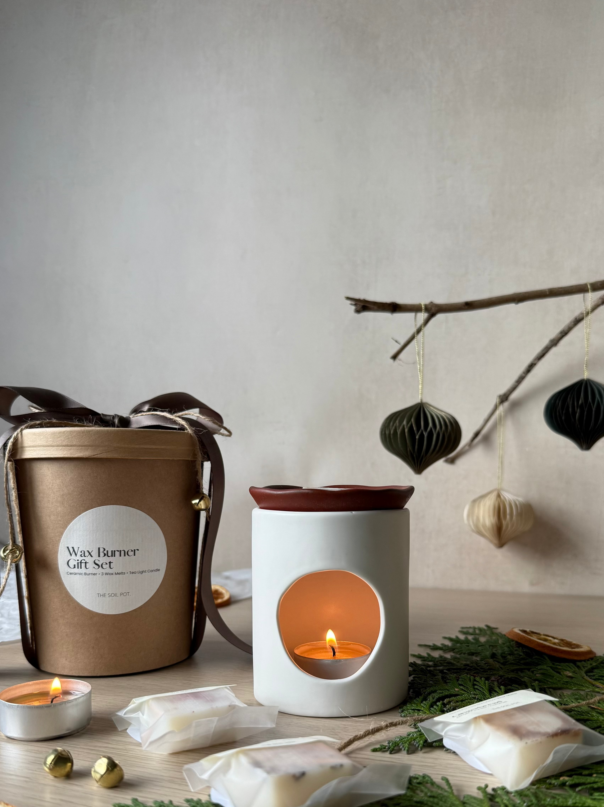 Wax burner gift set with a candle and decorative elements on a neutral background